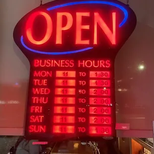 a neon sign for a business hours