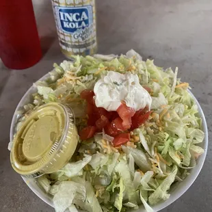 Cuenelli Bowl. Shredded rotisserie chicken, Rice and beans buried under the generous amount of lettuce.