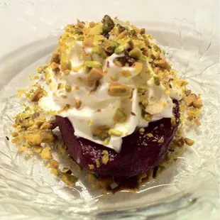 Dessert - red wine poached pear with whipped cream and pistachios