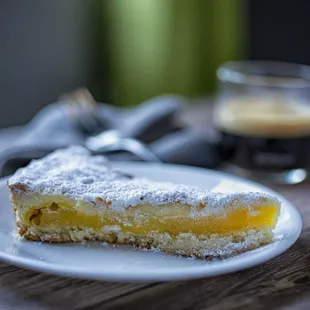 Grandmother Cake-Pastry cream with a hint of lemon on a base of short pastry, covered with pine nuts, almonds, and powdered sugar.