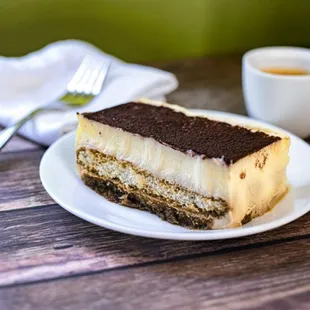 Tiramisu - Espresso drenched cake, layered with mascarpone cheese mousse, sprinkled with cocoa sugar.