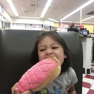 a little girl eating a doughnut