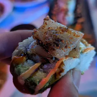 a hand holding a sandwich