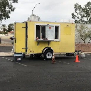 a yellow food truck parked in a parking lot