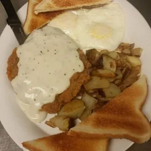 Country fried steak with eggs and potatoes