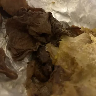 Oxtail roti with huge piece of paper inside of it.