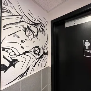 a black and white drawing of a woman on a wall