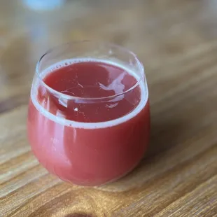 a glass of juice on a wooden table