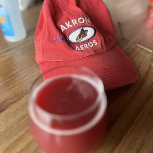 a red hat and a drink on a table