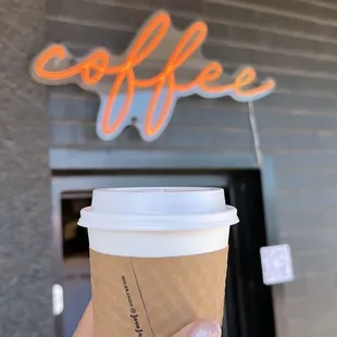 a hand holding a coffee cup