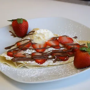 Strawberry Crepe with fresh strawberries, Nutella drizzle, powdered sugar and whipped cream. Also available gluten free.