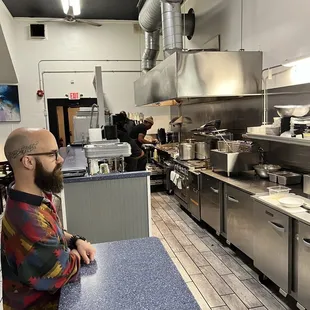a man sitting at a counter in a commercial kitchen