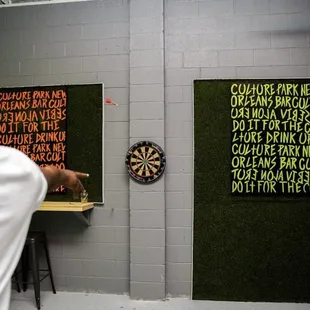 a man standing in front of a dart board
