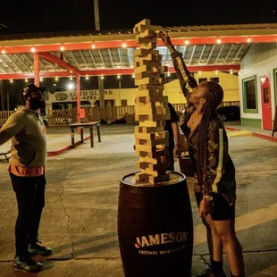 a man and a woman playing a game of giant blocks