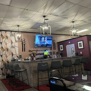 a bar with chairs and a television