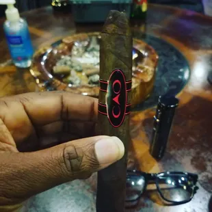 a hand holding a cigar