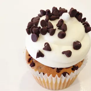 a cupcake with white frosting and chocolate chips