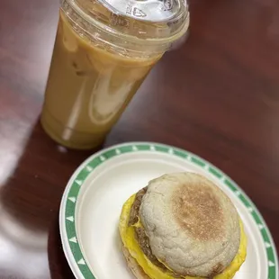 Iced latte with almond milk and egg, cheese, and sausage breakfast sandwich