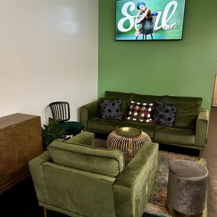  a living room with green couches and a television