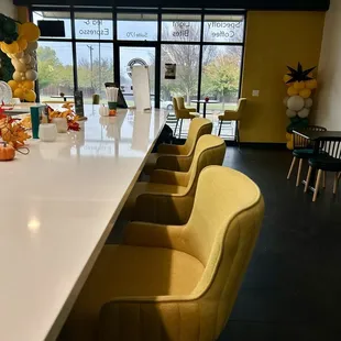  a long bar with yellow chairs