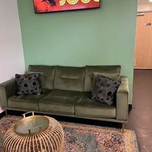  a living room with a green couch and coffee table
