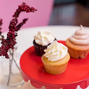 three cupcakes on a cake stand