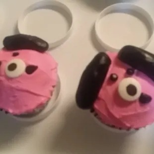 two decorated cupcakes with pink frosting