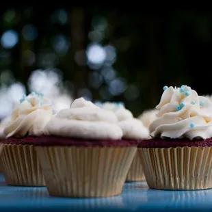 cupcakes with white frosting and blue sprinkles