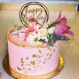 Pink cake with fresh flowers and gold accents