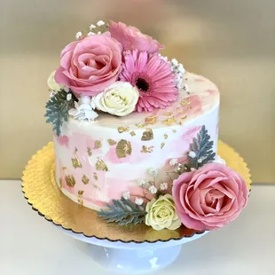 Pink and white cake with fresh flowers and gold accents