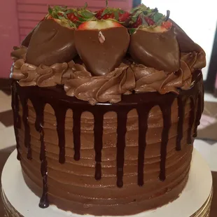 Chocolate Lovers Layered cake topped with chocolate buttercream frosting and chocolate dipped strawberries.