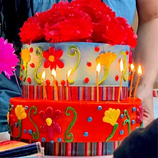 a woman lighting candles on a cake