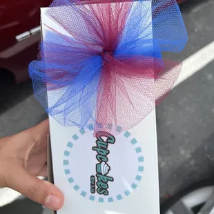 a person holding a cupcake box