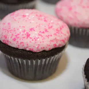 chocolate cupcakes with pink frosting and sprinkles