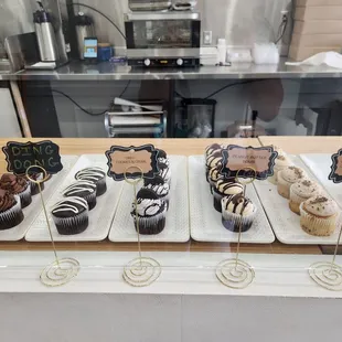 a variety of cupcakes in a display case