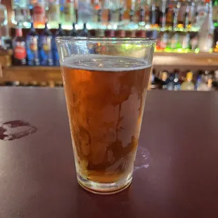 a glass of beer on a bar