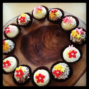 a circle of cupcakes on a wooden plate