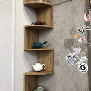a corner shelf with a tea pot and teapot