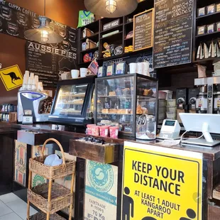 a coffee shop with a sign that says keep your distance