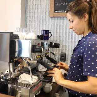 a woman preparing a cup of coffee