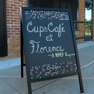 a chalkboard sign on a sidewalk