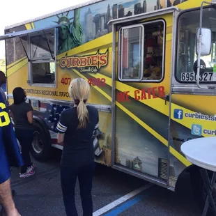 a woman standing in front of a food truck