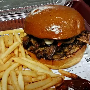 Pulled pork sandwich with chipolte honey bbq sauce and fries.
