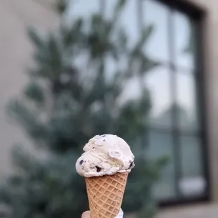 a hand holding an ice cream cone