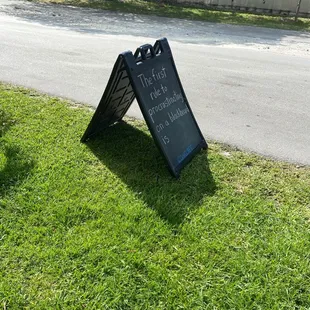 a blackboard sign in the grass