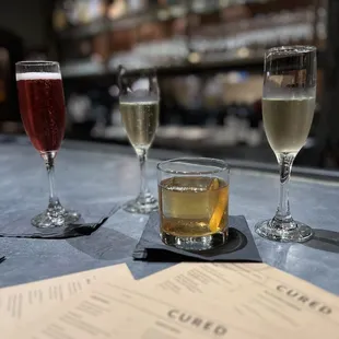 three glasses of wine and a menu on a bar