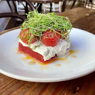 Compressed watermelon salad with blistered, chilled heirloom tomatoes, herbed goat cheese, carrot tops, fennel seeds, and chili oil