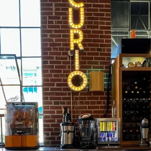 a bar with a brick wall and a neon sign that says curio