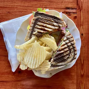 Vegan pastrami sandwich on marble rye with kettle chips