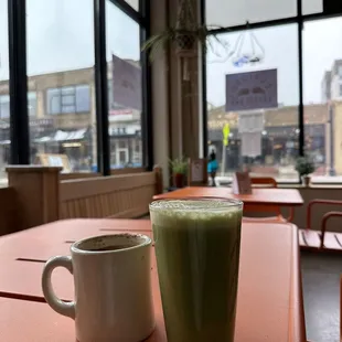 a cup of green liquid and a mug of coffee